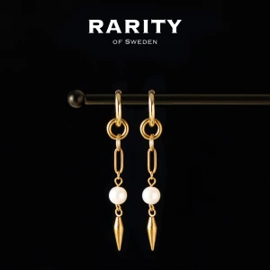 Aurora Earring - Gold: Guldörhängen med pärlor och nitar - Snygga örhängen i guld från Rarity of Sweden med hängande kedjor, vita pärlor och spetsiga detaljer längst ner. Perfekt för dig som vill ha en cool och elegant look med lite edge. Kombinera med dina favoritaccessoarer för att sticka ut.