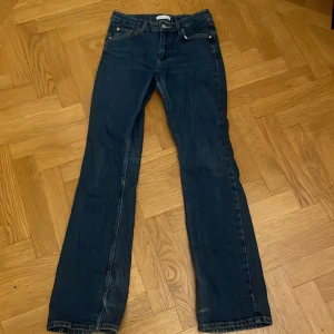Mörkblå bootcut jeans från Gina tricot  - Säljer ett par mörkblå bootcut jeans från Gina tricot i storlek 38. Klassisk femficksmodell med snygga kontrastsömmar och knapp med logga. Jeansen har en bootcut passform och är tillverkade i slitstarkt denimtyg. Dessa jeans är köpta på Plick, tyvärr passade de inte. Som ni ser så är en utav hälarna lite sliten. Hon jag köpte byxorna av sa inte att ena hälen var sliten så är noga med att skriva det i min annons, därav priset🫶🏻💕
