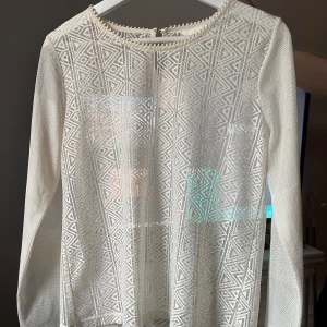 Vit spetsblus från H&M med mönster - Superfin vit blus från H&M i spets med knapp i nacken. Kommer ejj till användning 💞
