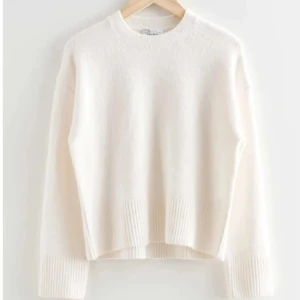 Vit stickad tröja - Säljer en enkel och fräsch vit stickad teöja från & other stories. Perfekt för att hålla sig varm och snygg under kyliga dagar.