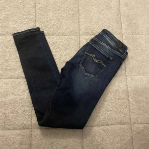 Mörkblå replay jeans - Snygga mörkblå jeans med coola kontrastsömmar på bakfickan. Jeansen har klassisk femficksdesign och smal passform som sitter tajt längs benen. Perfekta till sneakers eller boots och funkar året runt.