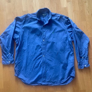 Blå skjorta från Ralph Lauren XL - Hej, säljer en klassisk skjorta från Ralph Lauren. Skick 8/10. Färg, ljusblå. Strl Xl, passar en som är emellan 190-200 cm. Inga defekter. Öppen för att förhandla priser! 
