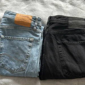 Jeans från Jack&Jones - Säljer två par jeans från Jack & Jones. Det ena paret är ljusblåa och det andra svarta.