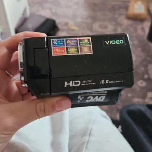 Svart videokamera med 16.0 megapixel - Säljer en svart videokamera med 16.0 megapixel och HD 720p videoinspelning. Kameran har 16x digital zoom och DIS-stabilisering. Den använder ett Li-Ion NP-120 batteri och har en praktisk design för enkel hantering.