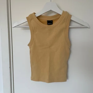 Orange linne från Gina Tricot - Säljer en stilren croppad orange topp från Gina Tricot. Toppen har en ribbad design och är i storlek xxs. 🧡
