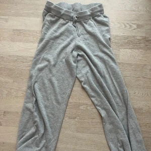 Grå mjukisbyxor från Bubbleroom - Säljer ett par grå mjukisbyxor från Bubbleroom. Byxorna har en bekväm resårmidja med snörning och är tillverkade i ett mjukt material. Perfekta för en avslappnad stil.