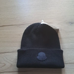 Svart ribbad mössa från Moncler - En svart mössa från Moncler