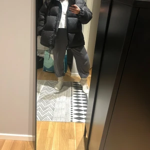 Svart pufferjacka med huva - Säljer en svart pufferjacka med huva. Jackan har en dragkedja framtill och är perfekt för kyligare dagar. Den har en oversized passform som ger en avslappnad stil. Oversize på mig som bär vanligtvis xs och jackan är storlek M