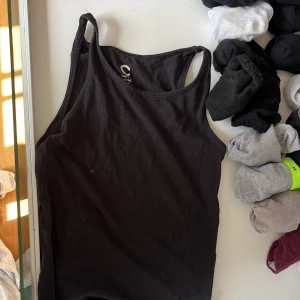 Svart linnetopp från Cubus - Säljer en enkel och stilren svart linnetopp från Cubus. Perfekt för lager-på-lager eller att bära som den är. Linnet har smala axelband och en rund halsringning.