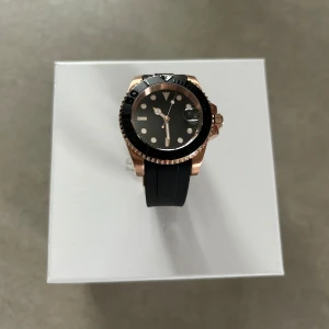 Seiko Submariner Mod 40mm – NH35, Roséguld, Nybyggd - Byggd med passion för klockor – säljer nu en exklusiv Seikomod Submariner i roséguld, 40 mm. Klockan är utrustad med ett NH35 urverk, vilket är ett välkänt, pålitligt och välrenommerat automatiskt urverk tillverkat av det japanska märket Seiko. NH35 är känt för sin precision och längvariga hällbarhet. Obs. Klockan är special-byggd och enbart urverket är av varumärket seiko, dvs seikomod. 