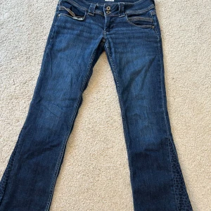 Blå jeans med leopardmönster - Snygga blå jeans med låg midja och bootcut model. Sytt på ett leopard mönster som gör de till bootcut. Andvänd få antal gånger. Storlek 31x32 men små i storleken. 