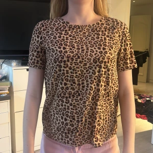 Leopardmönstrad topp från Pieces - Säljer en snygg leopardmönstrad topp från Pieces. Den har korta ärmar och en rund halsringning. Perfekt för att ge din outfit en trendig touch. 🐆