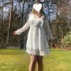 Vit klänning 💕 - Fin midsommar/konfirmation/avslutning/vardags klänning från ellos💖 denna klänningen är helt nyskick (har endast testats)💖 Jag skulle säga att den passar i storlekarna S-M ungefär💖 köpare står för frakt🙏  en söt vit klänning med volangdetaljer och v-ringning. Klänningen har långa ärmar och en luftig passform, perfekt för varmare dagar. Den dubbla kjolen ger en fin lager-på-lager-effekt. 