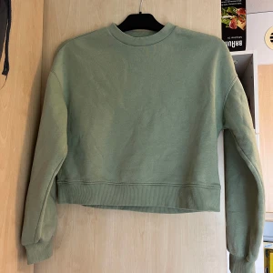 Grön croppad tröja från H&M Divided - Säljer en stilren grön croppad tröja från H&M Divided. Tröjan har långa ärmar och är tillverkad i bomull. Normal i storleken 💚