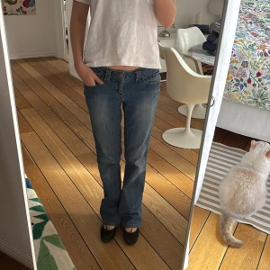Blå jeans med bootcut - Säljer ett par klassiska blå jeans med bootcut. De har en låg midja och en snygg passform som ger en avslappnad look. Perfekta för en casual stil.
