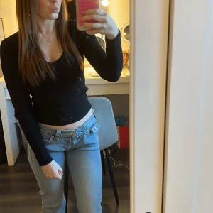 Blå bootcut jeans - Snygga blå bootcut jeans från true religion med en klassisk femficksdesign. Jeansen har en bekväm passform och är perfekta för en avslappnad stil. De är tillverkade i ett slitstarkt material och har en traditionell dragkedja och knapp framtill. Säljer då de är förstora, knappt använda, 1-3 gånger 