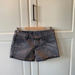 Gråa jeansshorts - Säljer ett par snygga lågmidjade jeansshorts pågrund av att dom är försmå. Dom har coola röda detaljer men vet tyvärr inte vart dom är ifrån då dom inte har en etikett. Skulle uppskatta storleken som en 34. Kan såklart fixa fler bilder! 🩷köpt för 230kr, säljer för 200kr