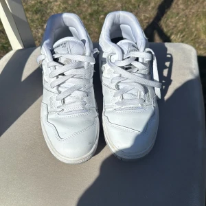 Vita sneakers från New Balance - Snygga vita New Balance 550 sneakers med klassisk design och snörning. Perfekta för en stilren look. De har en rund tå och är tillverkade i syntetmaterial.