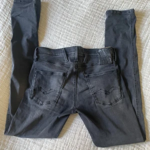 Grå jeans från Replay - Snygga grå jeans från Replay i modellen Anbass. De har en klassisk femficksdesign och en stilren look. Perfekta för en avslappnad stil med en touch av elegans.