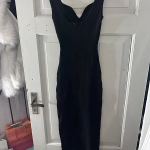 Svart klänning - Elegant svart klänning med en tight passform. Perfekt för en stilren och sofistikerad look. Klänningen har en klassisk design som framhäver figuren.