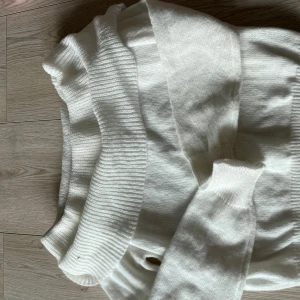 Vit stickad tröja från Zara - Säljer en mysig vit stickad tröja från Zara. Tröjan har en ribbad struktur och en bred krage som ger en stilren look. Perfekt för kyligare dagar.🩷🩷