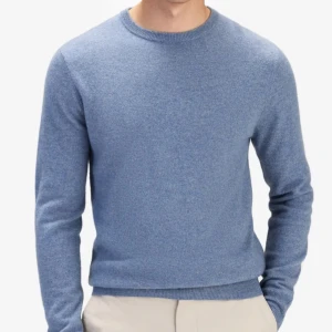 Blå stickad tröja - Säljer en stilren blå stickad tröja med rund hals och långa ärmar. Perfekt för kyligare dagar och passar bra till både jeans och chinos. Ett måste i garderoben för en klassisk look.