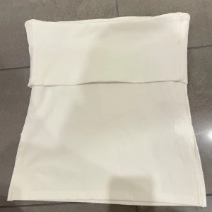 Vit tubtopp - Säljer en stilren vit tubtopp. Perfekt för sommardagar eller att matcha med en snygg jacka. Enkel och elegant design.