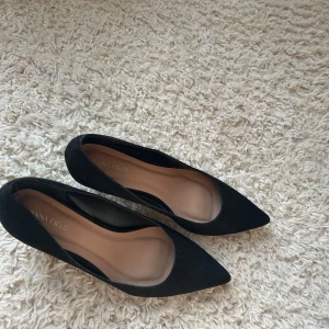 Svarta pumps från Anna Field - Snygga svarta pumps från Anna Field med spetsig tå och klack. Perfekta för en elegant look. Tillverkade i ett stilrent material som ger en klassisk känsla.
