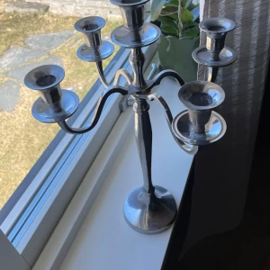 Silverfärgad kandelaber - Elegant silverfärgad kandelaber med fem armar. Perfekt för att skapa en stilfull atmosfär i hemmet. Den har en klassisk design med mjuka kurvor och en stabil bas.  Fint skick, se bilder☀️💛 Pris kan diskuteras vid seriöst intresse.