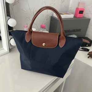 Longchamp väska - Måtten är 22,5*24*11 cm och färgen är navy blue. Passar perfekt för en dag på stan. (Pris går att diskutera vid snabbt köp)