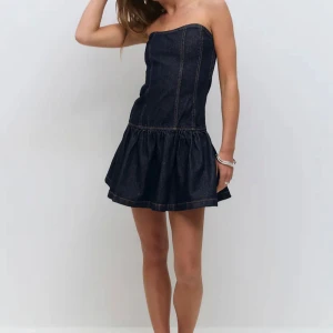 Mörkblå axelbandslös jeansklänning - Supersnygg mörkblå jeansklänning från Gina Tricot. Oanvänd med lappen kvar. Strl S. 