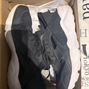 Svarta Nike sneakers med vit sula - Snygga svarta Nike sneakers med vit, chunky sula och klassisk snörning. Ovandelen är i mesh och syntet för en sportig vibe och bra andningsförmåga. Perfekta för dig som gillar streetstyle och vill ha bekväma skor till vardagen.