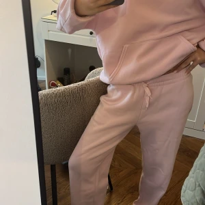 Ljusrosa mjukisbyxor från Gina Tricot - Supermysiga ljusrosa mjukisbyxor och mjukis hoddie från Gina Tricot, basically basics-kollektionen. Byxorna har resår och snörning i midjan för perfekt passform och är gjorda i mjuk bomull. Perfekta för chill dagar hemma eller när du vill vara extra comfy. 500kr plus frakt! 