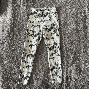 Svarta och vita leggings från SOC - Säljer ett par snygga leggings från SOC i storlek M. De har ett svart och vitt abstrakt mönster och är tillverkade i ett stretchigt syntetmaterial som andas. Perfekta för träning eller chill dagar. Hög midja och tight passform.