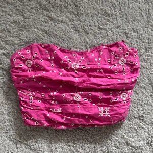 Rosa korsett från Zara - Superfin rosa korsett från Zara med vita broderade blommor och smockad rygg.