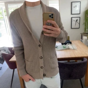 Beige kofta/Blazer - Snygg beige kofta/blazer från Less Worries i stickad bomull. Modellen har sjalkrage, knappar framtill och två praktiska fickor. Skicket är i princip nyskick, använd vid 2-3 tillfällen! Nypris är 1500, mitt pris endast 699!! Hör av er vid frågor och funderingar!