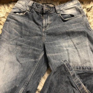Blå jeans från Bershka, strl 34 - Säljer ett par klassiska blå jeans från Bershka i storlek 34. Jeansen har fem fickor, bälteshällor och en snygg tvättad look. Har haft på mig dessa kanske 3 gånger förut.