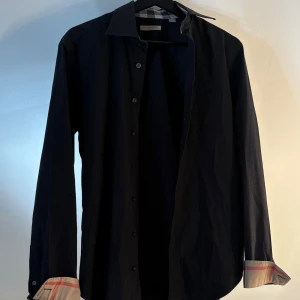 Svart skjorta från Burberry - Säljer en fett skjorta från burberry i st S-M. Den är i bra skick och kommer till ett bra pris. Bara att höra av sig vid minsta intress😄🤝