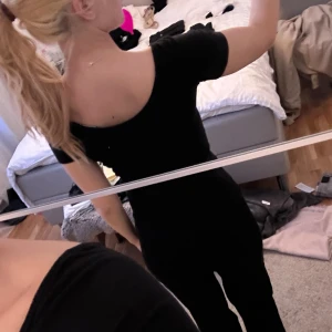 Svart T-shirt - En svart T-shirt med lite djupare urringning i ryggen som är figursydd, är i bra skick Storlek xs