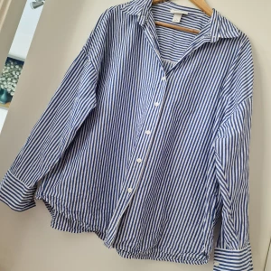 Blåvit randig skjorta från Monki - Kan fixa fri frakt men kontakta mig innan köp 🌸Snygg oversized skjorta från Monki i blåvitt randigt mönster. Skjortan har klassisk krage, långa ärmar och knäppning framtill med vita knappar. Tillverkad i mjuk bomull som känns skön mot huden. Perfekt för en chill och stilren look. Storlek L, använd men bra skick