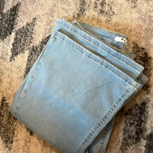 Ljusblå bootcut jeans från NA-KD - Snygga ljusblå jeans från NA-KD med klassisk femficksdesign och bootcut-ben. Jeansen har hög midja och är tillverkade i mjukt denimtyg som sitter skönt och med stretchiga:) 