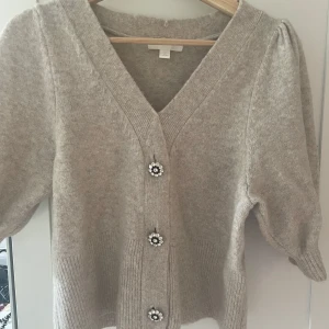 Stickad T-shirt  - Supersöt stickad T-shirt med glittrande diamant knappar från h&m💞 köptes second hand och förra ägaren har sytt igen där fram så att knapparna inte går att öppna. Men det är supersnyggt gjort och inget man märker😍 superfint skick och inte nopprig 💞 