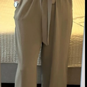 Jumpsuit  från Vero Moda L - Snygg jumpsuit  från Vero Moda i storlek L. Modellen är wide med hög midja och knytskärp i midjan. Jumpsuit har fickor på sidorna och är tillverkade i ett mjukt, lätt material som känns luftigt. Perfekta för en chill och stilren look.