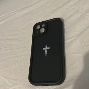 Svart skal med ett kors i mitten  - Helt nytt