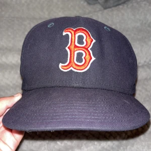 Boston Red Sox keps från New Era - Mörkblå Boston Red Sox keps från New Era med klassiskt röd B-logga framtill, MLB-logga bak och New Era-logga på sidan. Snygg broderade detaljer. Perfekt nu till sommaren! Hmu vid intresse!👍💯‼️