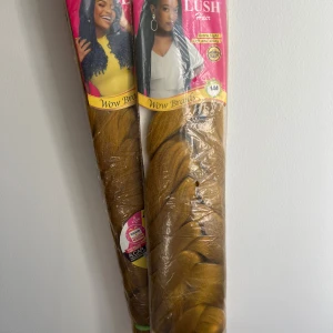 Lush Hair Wow Braids hår (Två paket) - Två paket Lush Hair Wow Braids i färgen gyllene blond. Extra lätt och glansigt, perfekt för flätor och kreativa frisyrer. Varje paket innehåller långt, mjukt hår som är enkelt att styla och trasselfritt.