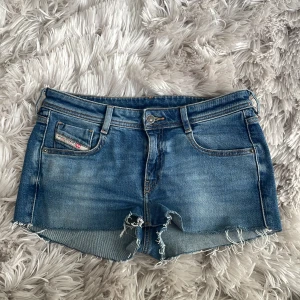 Blå jeansshorts från Diesel - Snygga blå jeansshorts från Diesel med råa, fransiga kanter och klassisk femficksdesign. Shortsen har mellanlåg midja och en cool tvättad look. Perfekta nu för sommaren. Storlek 29w. Shortsen är ett par avklippta jeans som jag gjorde till shorts! Ganska använda. Enda deftekten är att hällorna på sidorna har gått sönder lite(sista bilden), inget som man märker, går att sy ihop. Fråga gärna vid funderingar eller om mått!💗