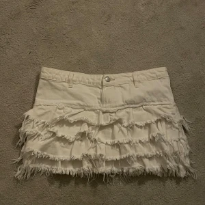 Vit kjol med fransar - Säljer en vit kjol me fransar! Midje mått ca 40-41. Från monki. Aldrig använd! Jätte bra skick, skriv vid intresse ❣️
