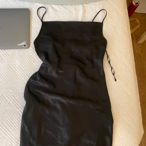 Svart klänning från Boohoo - så snygg festklänning från hm!! den är kort slipdress modell och har en cowl neck vilket är så snyggt till utekväll, fest, mm.. strl xs passar s, använd 1 gång bara💞💞