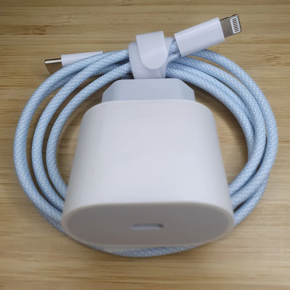 Säljer en vit laddare med en flätad kabel. Kabeln har en USB-C till Lightning-anslutning och är praktisk för snabb laddning av kompatibla enheter. Perfekt för dagligt bruk och enkel att ta med sig.. Asusteet.